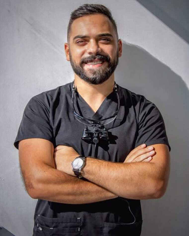 Dentist at Voyage Dental Aesthetics wearing the clinic's branded scrubs